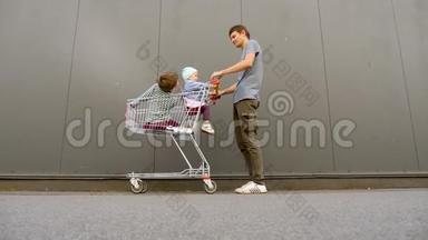 购物概念。 单亲家庭。 父亲带着兄弟姐妹去杂货店，购物中心。 快乐爸爸在购物